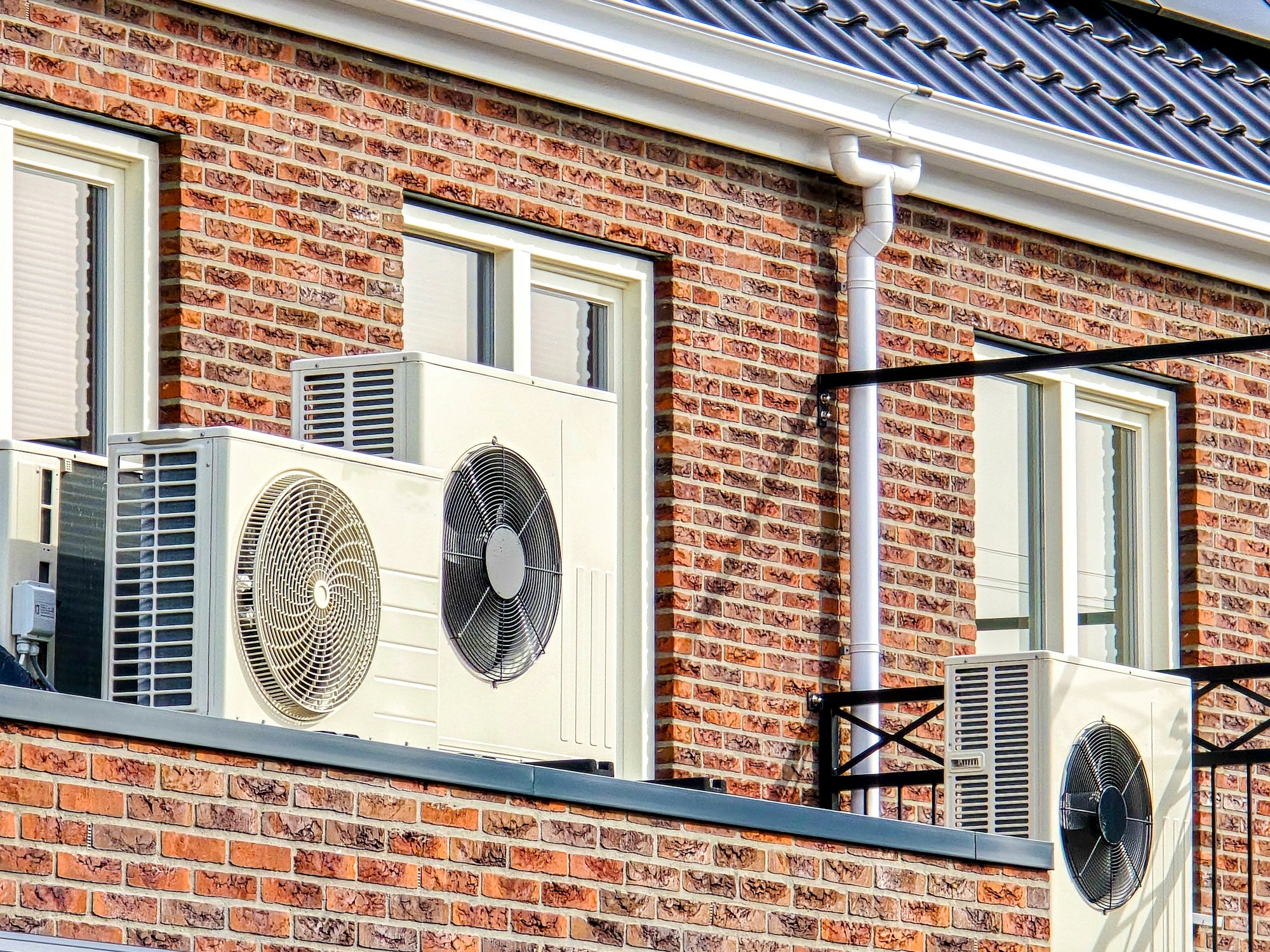 air source heat pump unit installed outdoors at a modern home with solar panels in the Netherlands